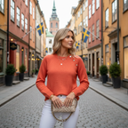Blonde woman in orange knit sweater with heart button in Stockholm
