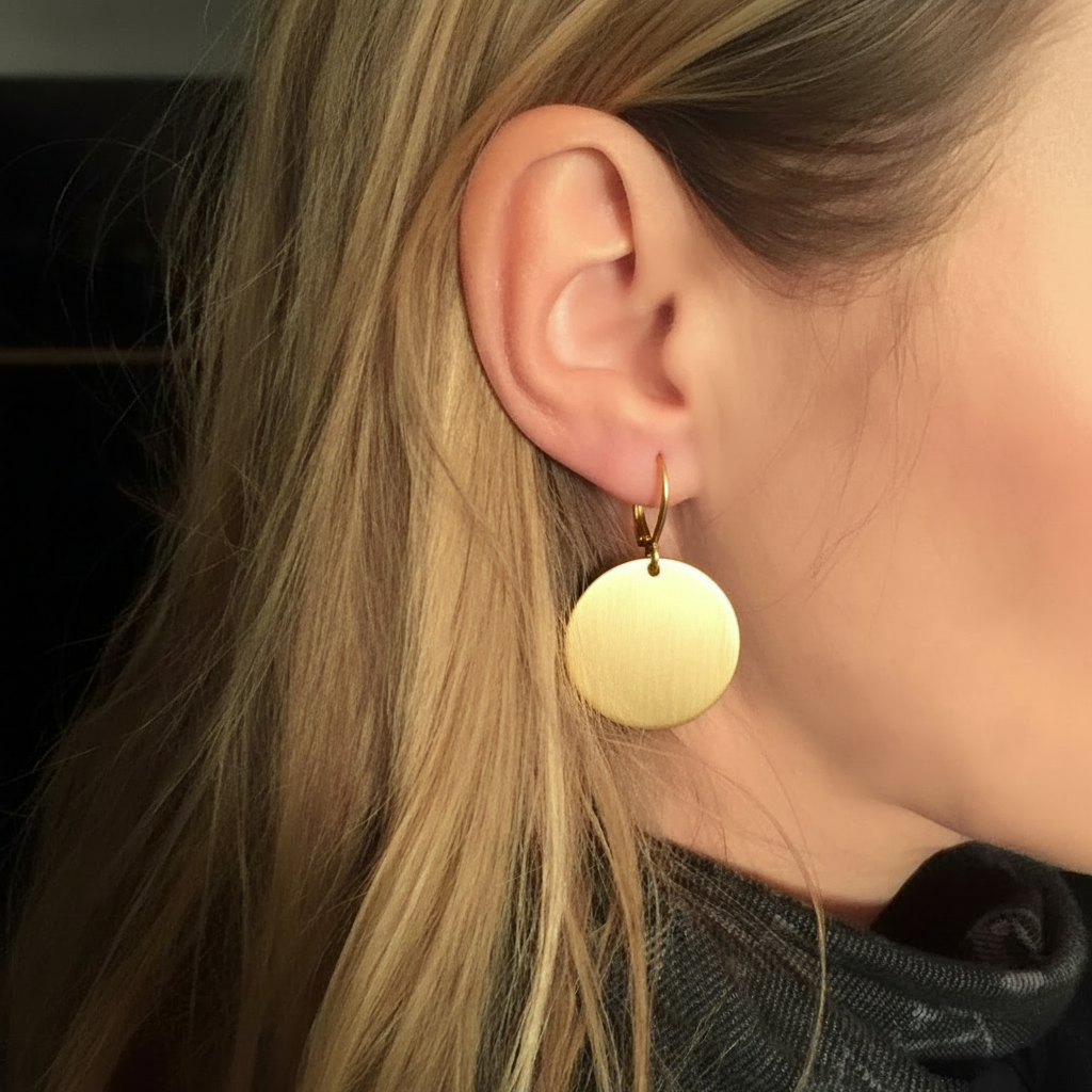Model wearing gold disc earrings