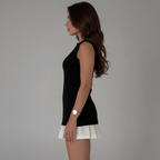 Side view of black top with white pleated skirt